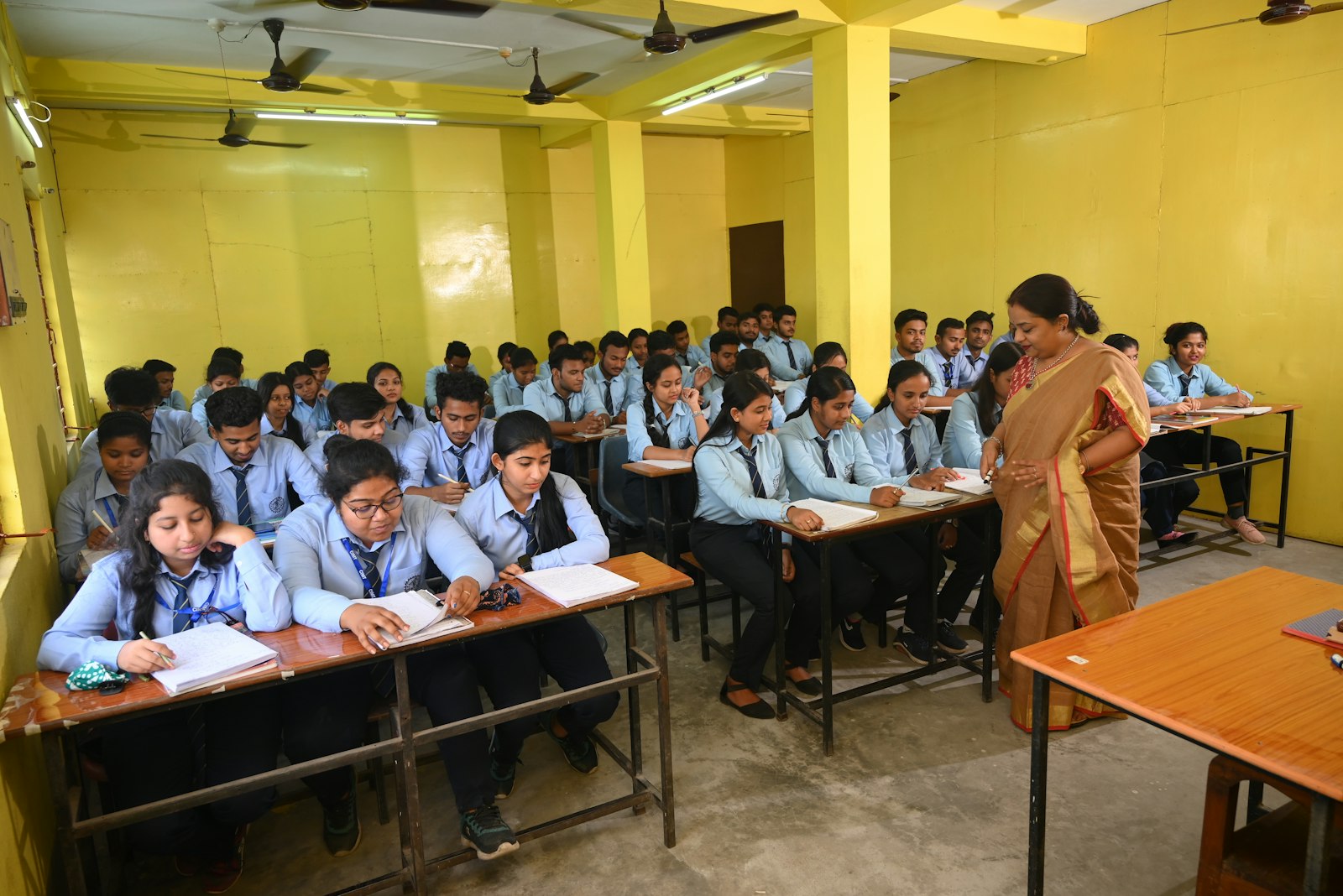 Uniformed students seated in rows in an Indian classroom, representative of the High School Program.